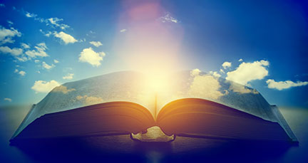 A book laying open overlayed with a blue sky with clouds and a sun shining